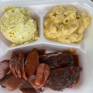 meat, macaroni, and cheese in a styrofoam container