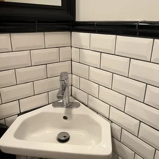 a white sink in a black and white bathroom
