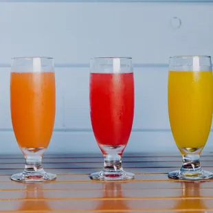 three glasses of juice on a wooden table