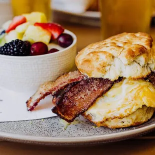 a breakfast of biscuits, bacon, and fruit
