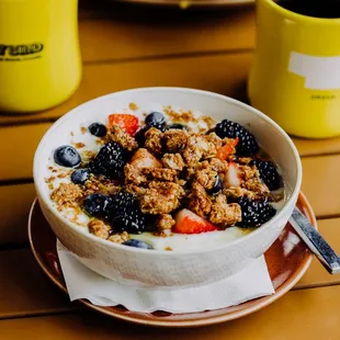 a bowl of granola with berries and strawberries