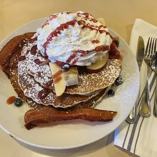 Buttermilk pancake stack with fresh fruit and cream, and bacon.