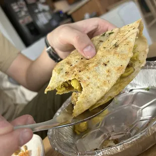 a person eating a quesadilla