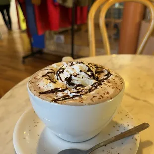 a cup of hot chocolate with whipped cream and chocolate drizzle