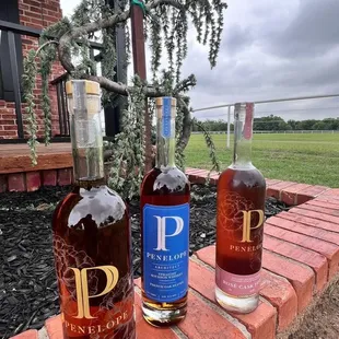 three bottles of wine on a brick ledge