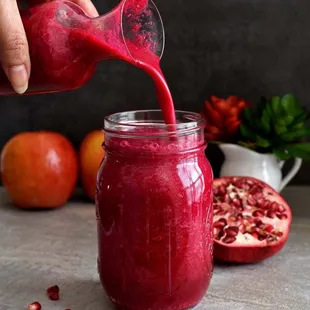 pomegranate being poured into a jar