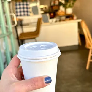 a hand holding a cup of coffee
