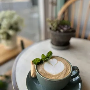 a cup of coffee with a leaf on top