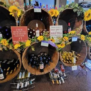 a display of wine bottles and sunflowers