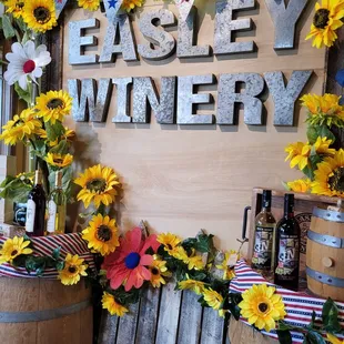 a display of sunflowers and bottles of wine