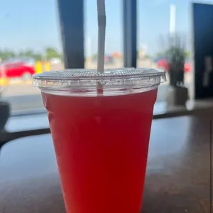 a red drink in a plastic cup