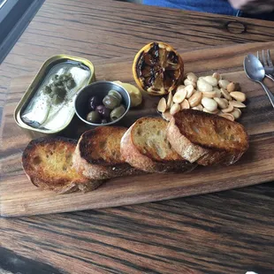 Sardine plate. Yummy sardines from a tin with olives, almonds and crostini.