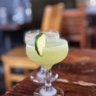 a cocktail with a cucumber garnish
