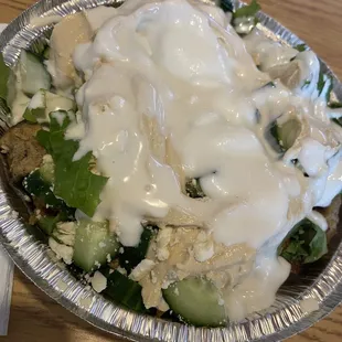 Chicken Shawarma bowl w/ lettuce, feta, cucumbers and white rice. Topped w/ tahini and garlic sauce