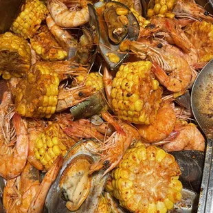 shrimp, corn, and corn cobs in a pan