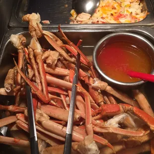 a tray of crab legs with dipping sauce