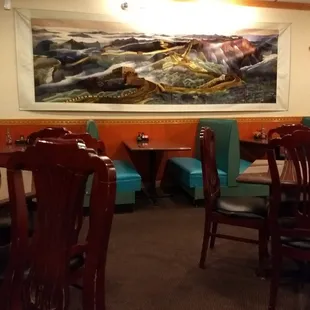 a restaurant with a large painting on the wall