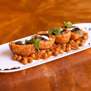 SAMOSA CHAAT (V)
seasoned potatoes and peas in a crispy pastry shell, channa masala, yogurt, tamarind and mint chutney