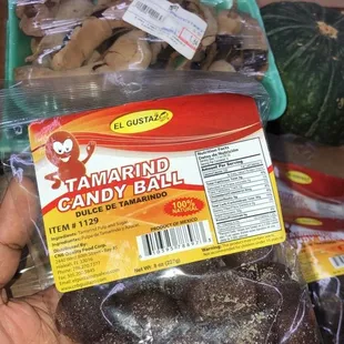 a hand holding a bag of caramel candy balls