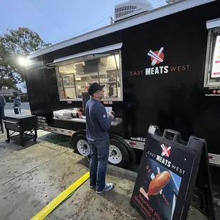 a man standing in front of a food truck
