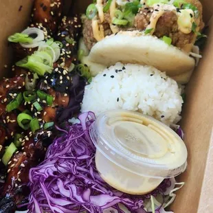 Two combo plate with a ginger chicken bao and 2 chicken yakitori with rice and cabbage salad