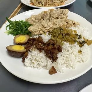 a plate of rice, meat, and vegetables