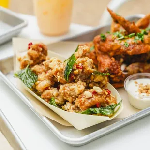 a tray of fried wings with dipping sauce