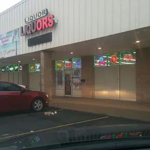 a red car in front of a liquor store