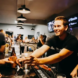 a man serving a beer at a bar