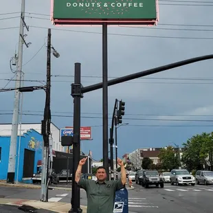 a man holding up a donut sign