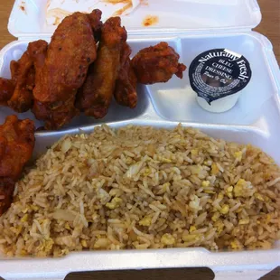 chicken wings, rice, and corn on a styrofoam container