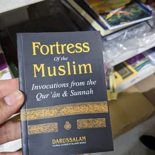 a hand holding a book about fortresss of the muslim