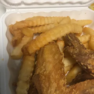 a takeout box of fried chicken and french fries