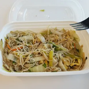 a takeout container with noodles and vegetables