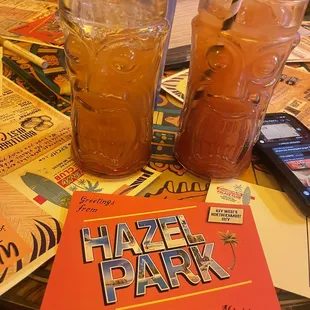 two glasses of iced tea and a book on a table