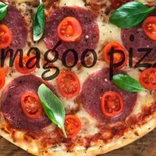 a pizza with pepperoni, tomatoes, and basil