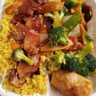Roast pork with mixed vegetables, fried rice, and  an egg roll.