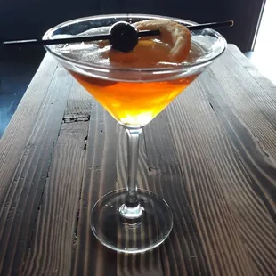 a martini with an orange garnish