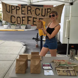 a woman holding a sign that says upper cup coffee