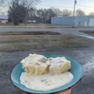 a hand holding a plate of ice cream