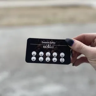 a hand holding a coffee capsule