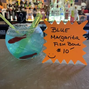 a blue margarita fish bowl with a straw in it