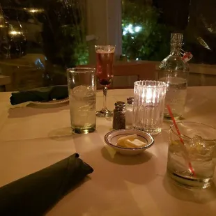 a table set with glasses, plates, and utensils