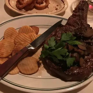 a plate of steak with chips and a knife