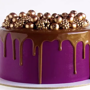 Sponge cake decorated with gold berries and chocolate drips