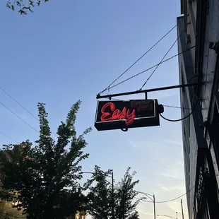 a neon sign hanging from the side of a building