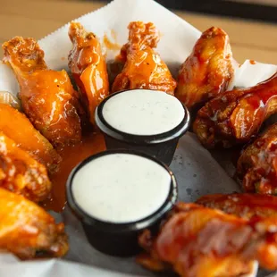 a basket of chicken wings with dipping sauce