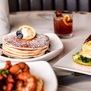 a plate of pancakes and a plate of eggs benedicts