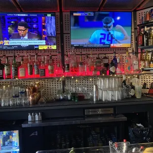 a bar with two televisions on the wall