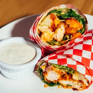 Fried chicken wrap with buffalo sauce, lettuce, onion, cucumber, cheddar cheese, Ranch and a choice of side